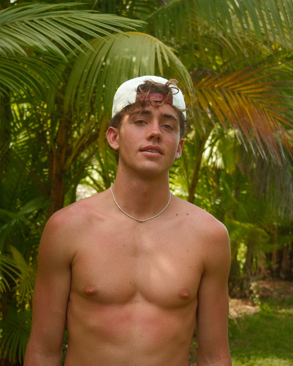 Man wearing a cream & red hat backwards